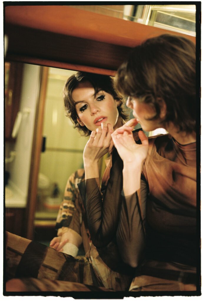 mujer pintandose los labios en un espejo